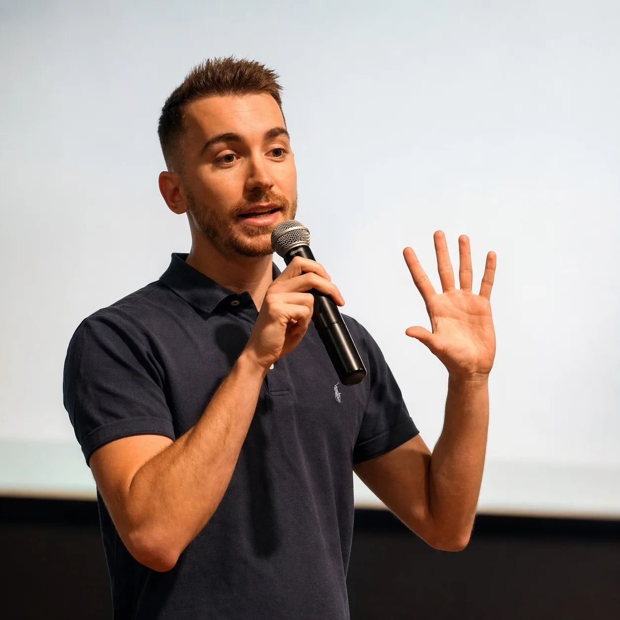 Anthony Basille, conférencier, micro en main, sur scène
